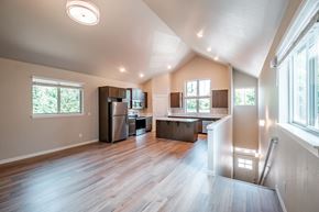 Forest Grove house for rent - an open kitchen and living room with wood floors and a large window