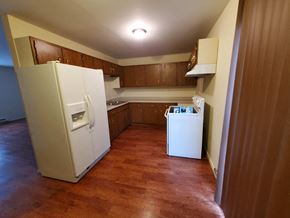 Lima apartment for rent - A kitchen with a white fridge and wooden floors.