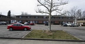 Lima apartment for rent - A red car is parked in a parking lot in front of apartment buildings.