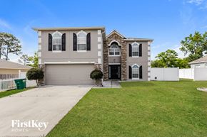 Deltona house for rent - A house with a garage and a driveway is for sale.