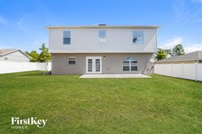 Deltona house for rent - A house with a white fence and a grassy yard.