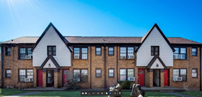 Fort Worth apartment for rent - a row of brick houses with red doors and white roofs