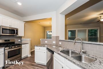 Mcdonough house for rent - a kitchen with white cabinets and granite counter tops