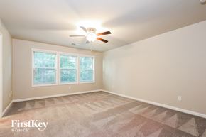 Mcdonough house for rent - a bedroom with a ceiling fan and a window