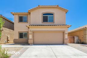 Tucson house for rent - a beige house with a garage door in front of it