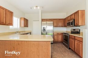 Tucson house for rent - a kitchen with wooden cabinets and stainless steel appliances
