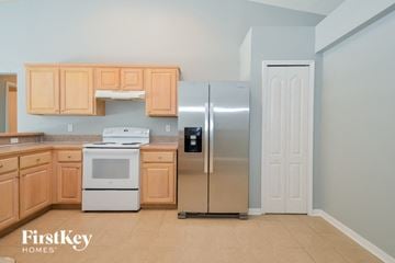 Jacksonville house for rent - A kitchen with wooden cabinets and a stainless steel refrigerator.