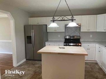 Douglasville house for rent - A kitchen with a wooden counter top and a stove.
