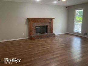 Douglasville house for rent - A living room with a fireplace and wooden floors.