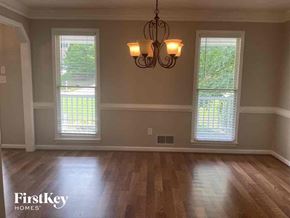 Douglasville house for rent - A room with wooden floors and a chandelier hanging from the ceiling.