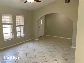 Port Charlotte house for rent - an empty living room with a ceiling fan and a tiled floor