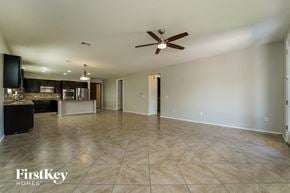 Tucson house for rent - an empty living room and kitchen with a ceiling fan