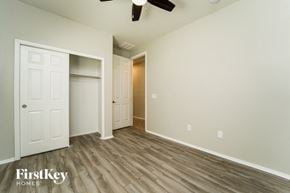 Tucson house for rent - an empty bedroom with a closet and a ceiling fan