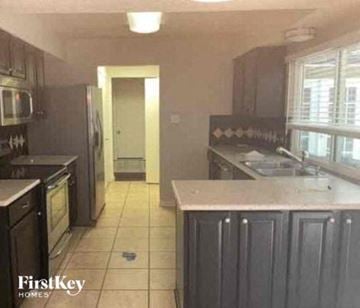Euless house for rent - a kitchen with a sink and a refrigerator