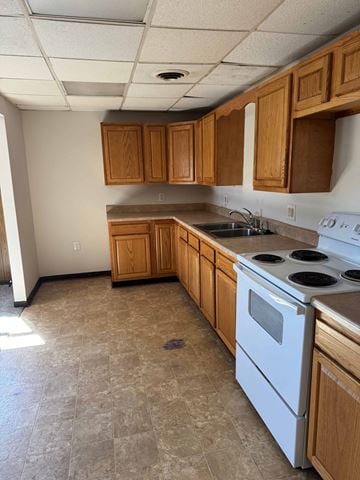 Lima apartment for rent - A kitchen with a white stove top oven and wooden cabinets.