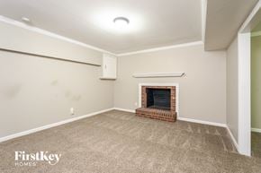 Lewisville house for rent - A room with a fireplace and a carpeted floor.