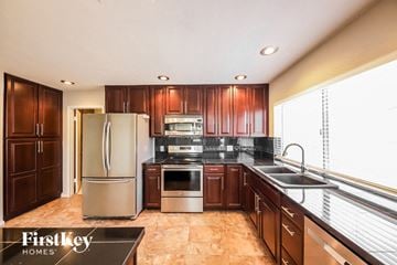 Phoenix house for rent - A kitchen with wooden cabinets and a refrigerator.