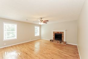Sugar Hill house for rent - A room with a fireplace and a ceiling fan.
