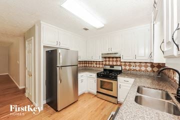 Sugar Hill house for rent - A kitchen with a stainless steel refrigerator and a stove top oven.