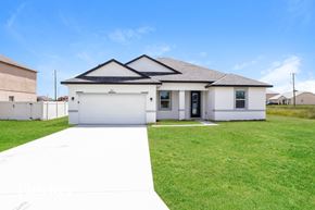 Poinciana house for rent - A white house with a black roof and a grey roof.