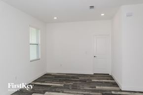 Poinciana house for rent - A room with a wooden floor and a white door.