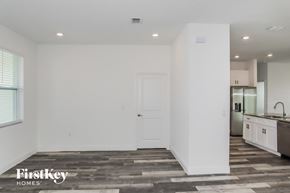 Poinciana house for rent - A spacious, empty room with a door and a window.
