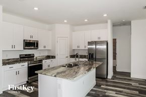Poinciana house for rent - A kitchen with a marble countertop and stainless steel appliances.