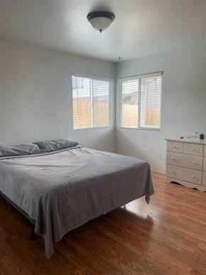 Orcutt house for rent - A bedroom with a bed, nightstand, and window with blinds.