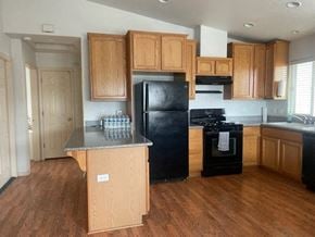 Orcutt house for rent - A kitchen with wooden cabinets and black appliances.