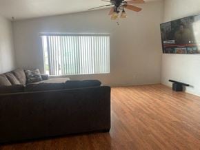 Orcutt house for rent - A living room with a couch, a ceiling fan, and a television.