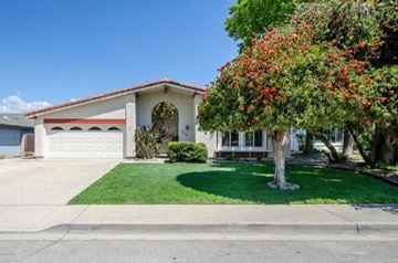 Santa Maria house for rent - A house with a red roof and a tree with red flowers in front.