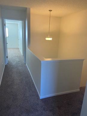 Santa Maria house for rent - A long hallway with a carpeted floor and a light hanging from the ceiling.