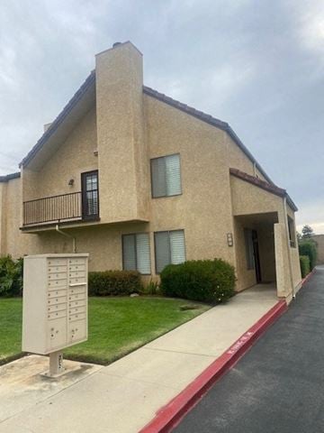 Santa Maria house for rent - A beige building with a red stripe on the sidewalk.