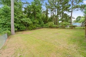 Jacksonville house for rent - A backyard with a fence and trees.