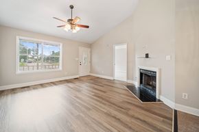 Jacksonville house for rent - A spacious living room with a fireplace and a ceiling fan.