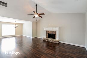 Loganville house for rent - a living room with a fireplace and a ceiling fan