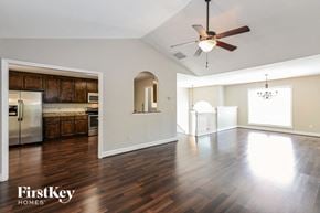 Loganville house for rent - an empty living room and kitchen with a ceiling fan