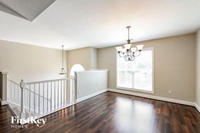 Loganville house for rent - an empty living room with a staircase and a large window