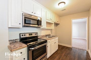 Loganville house for rent - a kitchen with stainless steel appliances and white cabinets