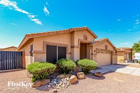 Surprise house for rent - A house with a black gate and a brown stucco exterior.