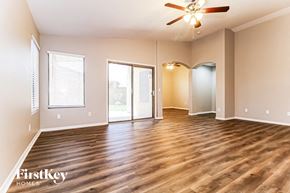 Surprise house for rent - A spacious room with wooden floors and a ceiling fan.
