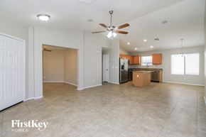 San Tan Valley house for rent - A spacious living room with a ceiling fan and tiled flooring.