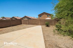 San Tan Valley house for rent - A brown house with a concrete walkway in front of it.