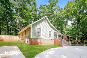 Charlotte house for rent - a green and brick house with a yard and stairs