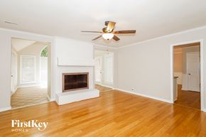 Charlotte house for rent - an empty living room with a fireplace and a ceiling fan
