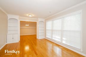 Charlotte house for rent - an empty living room with a large window and wood floors