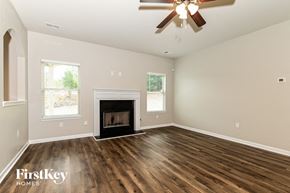 Mcdonough house for rent - a living room with a fireplace and a ceiling fan