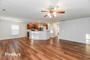 Summerville house for rent - an empty living room with a ceiling fan and a kitchen