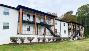 Riverdale apartment for rent - the exterior of an apartment building with a lawn and a staircase