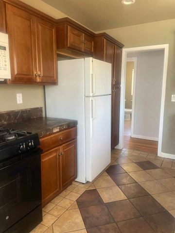 Santa Maria house for rent - A kitchen with a black stove and white refrigerator.